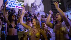 Dua orang wanita bertelanjang dada saat menggelar protes pelarangan aborsi di Rio de Janeiro, Brasil (13/11). Ribuan orang turun ke jalan untuk menggelar protes adanya larangan aborsi di Brasil. (AFP Photo/Mauro Pimentel)