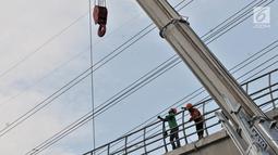 Aktivitas pekerja menyelesaikan proyek LRT Jabodebek di kawasan Cibubur, Jakarta, Senin (18/2). Tarif flat untuk moda transportasi massal ini ditetapkan setelah mendapat kepastian subsidi dari pemerintah. (Merdeka.com/Iqbal S. Nugroho)