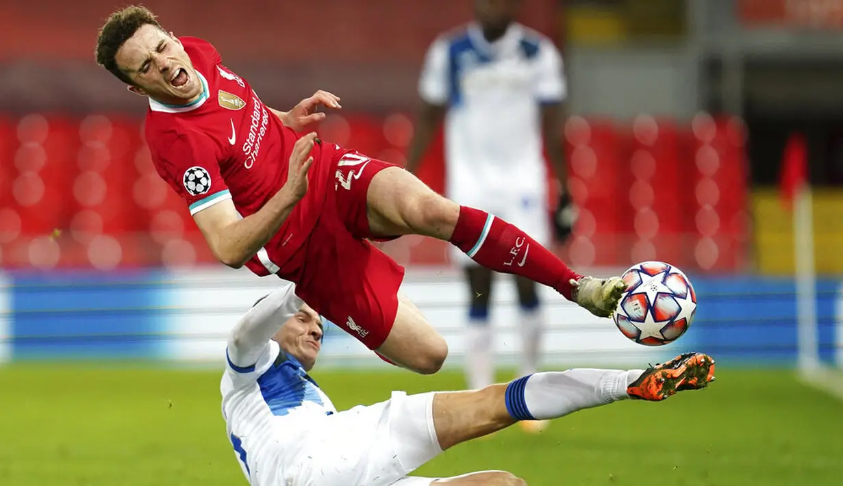 Pemain Liverpool, Diogo Jota, terjatuh saat berebut bola dengan pemain Atalanta, Marten de Roon, pada laga Liga Champions di Stadion Anfield, Kamis (26/11/2020). Liverpool takluk dengan skor 0-2. (AP Photo/Jon Super, Pool)