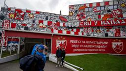 Sejumlah pengunjung berfoto dengan mural yang terletak di pintu masuk terowongan terkenal Stadion Rajko Mitic, Beograd, Serbia dua hari sebelum pertandingan sepak bola Grup G Liga Champions UEFA antara Crvena Zvezda (Red Star Belgrade) dan Manchester City pada 11 Desember 2023 waktu setempat. (AFP/Andrej Isakovic)