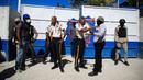Seorang petugas polisi mencoba menenangkan petugas polisi lainnya yang mengenakan pakaian jalanan saat dia mencoba memasuki markas polisi saat protes untuk mengecam tata kelola polisi yang buruk di Port-au-Prince, Haiti, 26 Januari 2023. Lebih dari 100 demonstran dilaporkan memblokir jalan, membakar ban, merusak kamera pengawas keamanan, dan kendaraan. (AP Photo/Odelyn Joseph)