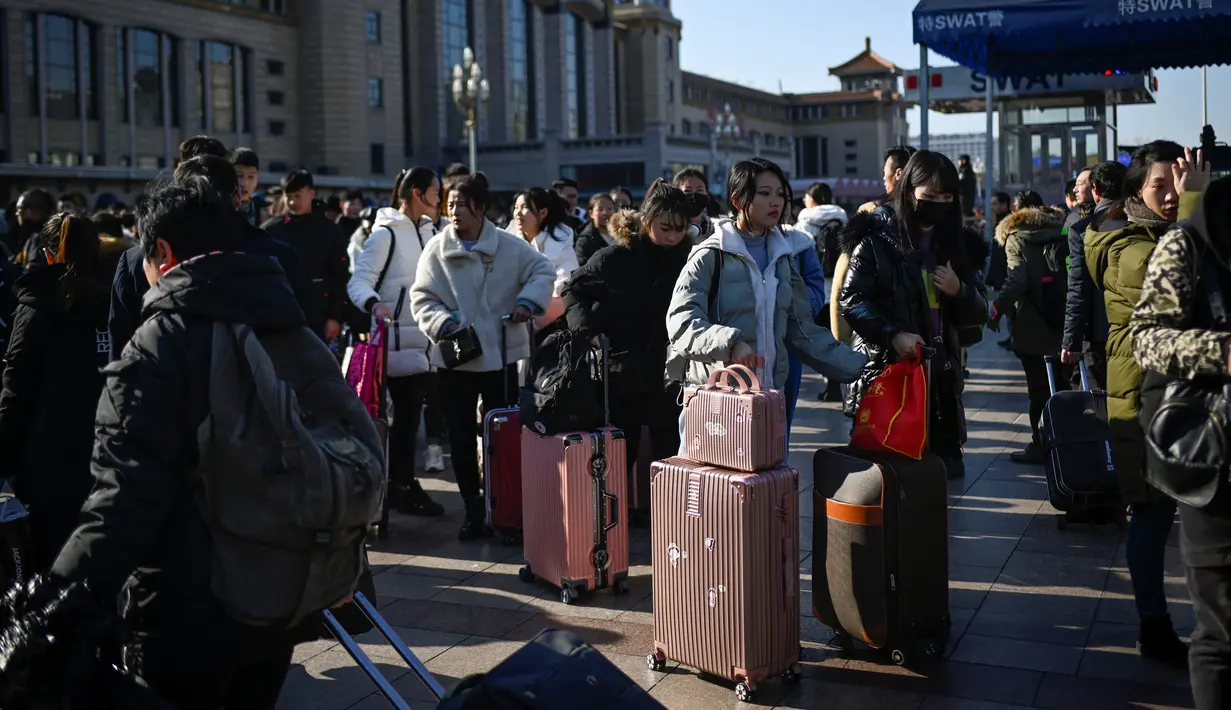 Calon pemudik menunggu kereta mereka di luar pintu masuk stasiun kereta api Beijing, Jumat (10/1/2020). Puluhan ribu warga China telah memulai migrasi manusia terbesar di dunia meninggalkan kota-kota besar menuju kampung halaman untuk merayakan Tahun Baru Imlek. (WANG ZHAO/AFP)