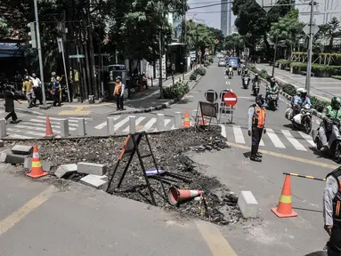 Petugas Dishub DKI Jakarta mengatur lalu lintas kendaraan saat uji coba penerapan sistem satu arah di Gondangdia, Jakarta Pusat, Kamis (8/4/2021). Uji coba yang berlangsung mulai 8-21 April mendatang merupakan bagian dari penataan kawasan Stasiun Gondangdia. (merdeka.com/Iqbal S. Nugroho)