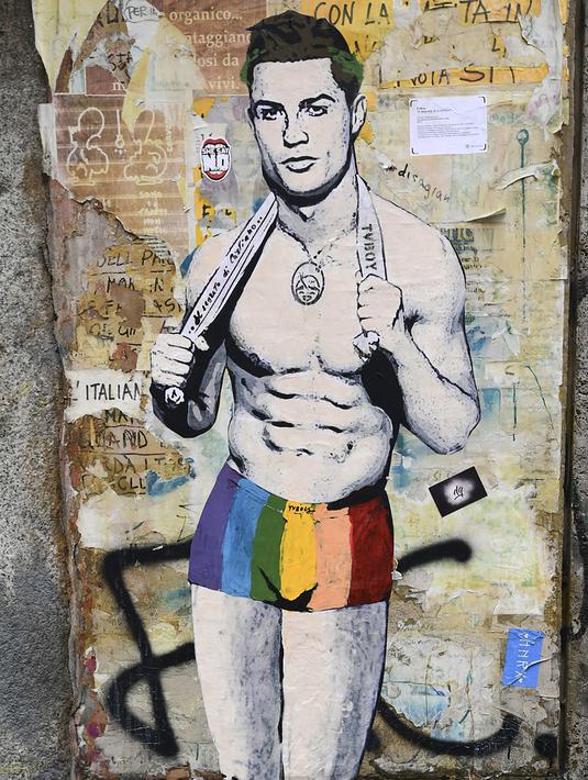 Sebuah mural dengan gambar bintang Juventus, Cristiano Ronaldo, yang terdapat di Milan, Senin (19/3). Mural berjudul Cristiano's Secret ini karya seniman Italia, TvBoy. (AFP/Miguel Medina)