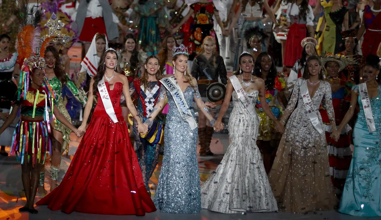 Miss Indonesia, Maria Harfanti (keempat kanan) beserta para peserta Miss World 2015 lainnya berpegangan tangan usai pnganugrahan juara di Sanya,  Cina, Sabtu (19/12). Indonesia berhasil menorehkan prestasi dengan menjadi juara ketiga. (REUTERS/Stringer)
