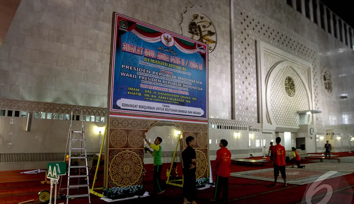Para pekerja saat menyiapkan baliho bertuliskan tentang informasi yang dipasang di ruang utama Masjid Istiqlal, Jakarta, (4/10/14). (Liputan6.com/Faizal Fanani) 