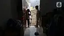 Dua orang anak bermain di depan pintu rumahnya yang terhimpit bangunan gudang di kawasan Mangga Dua Dalam, Jakarta, Kamis (12/12/2019). (Liputan6.com/Herman Zakharia)