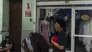 Warga berjalan melewati toko pakaian pribadi yang tutup di Havana, Kuba, Sabtu, 11 November 2023. (AP Photo/Ramon Espinosa)