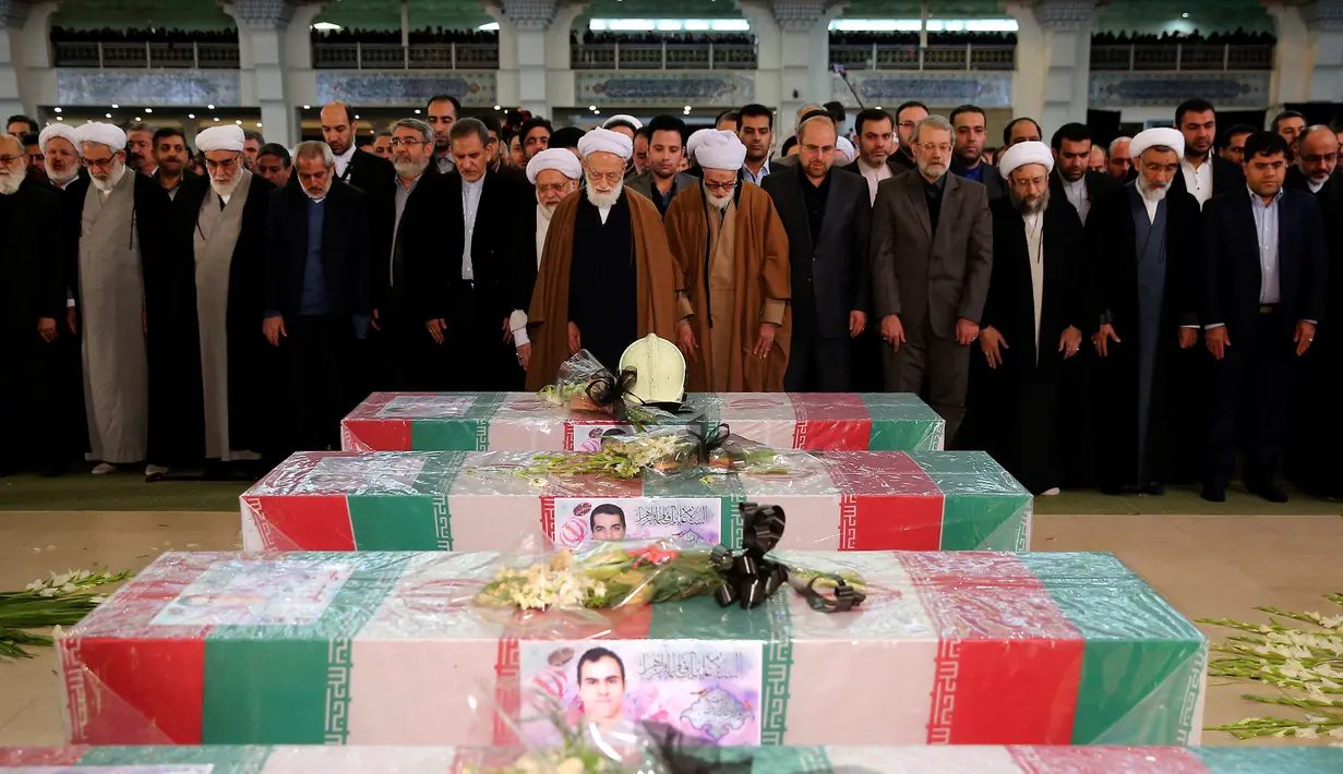 Warga Iran menggelar salat jenazah untuk 16 petugas pemadam kebakaran yang tewas dalam runtuhnya gedung yang terbakar pada 19 Januari, di Teheran, Iran, Senin (30/1). (AP Photo / Ebrahim Noroozi)