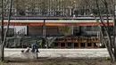 Seorang pria menikmati matahari di depan bar yang tutup di Lyon, Prancis, Kamis (1/4/2021). Prancis bersiap melakukan lockdown setelah pemerintah menemukan adanya lonjakan kasus COVID-19. (AP Photo/Laurent Cipriani)
