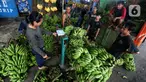 Pedagang tengah menurunkan pisang yang akan di jual di Pasar Lembang, Kota Tangerang, Kamis (28/3/2024). (Liputan6.com/Angga Yuniar)