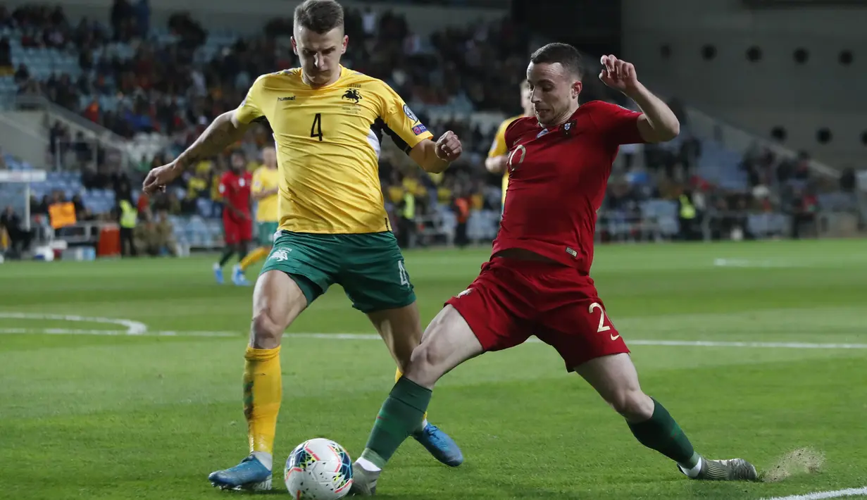 Penyerang Portugal, Diogo Jota berusaha melewati pemain Lithuania, Edvinas Girdvainis pada pertandingan Grup B Kualifikasi Piala Eropa 2020 di stadion Algarve di luar Faro, Portugal (14/11/2019). Portugal menang besar 6-0 atas Lithuania. (AP Photo/Armando Franca)