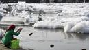 Seorang wanita berdoa di Sungai Yamuna yang tercemar di New Delhi, Sabtu (8/7). Pada 1909, air sungai ini tergolong sebagai "biru jernih" bila dibandingkan dengan Sungai Gangga yang berwarna kuning kecoklatan. (DOMINIQUE FAGET / AFP)