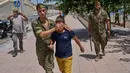 Seorang anak berusia 12 tahun yang menyeberang ke Spanyol tanpa pendamping menangis saat dikawal oleh seorang tentara Spanyol ke perbatasan Spanyol-Maroko dari wilayah kantong Spanyol di Ceuta, Senin, 3 Agustus 2026. (Foto AP/Bernat Armangue)