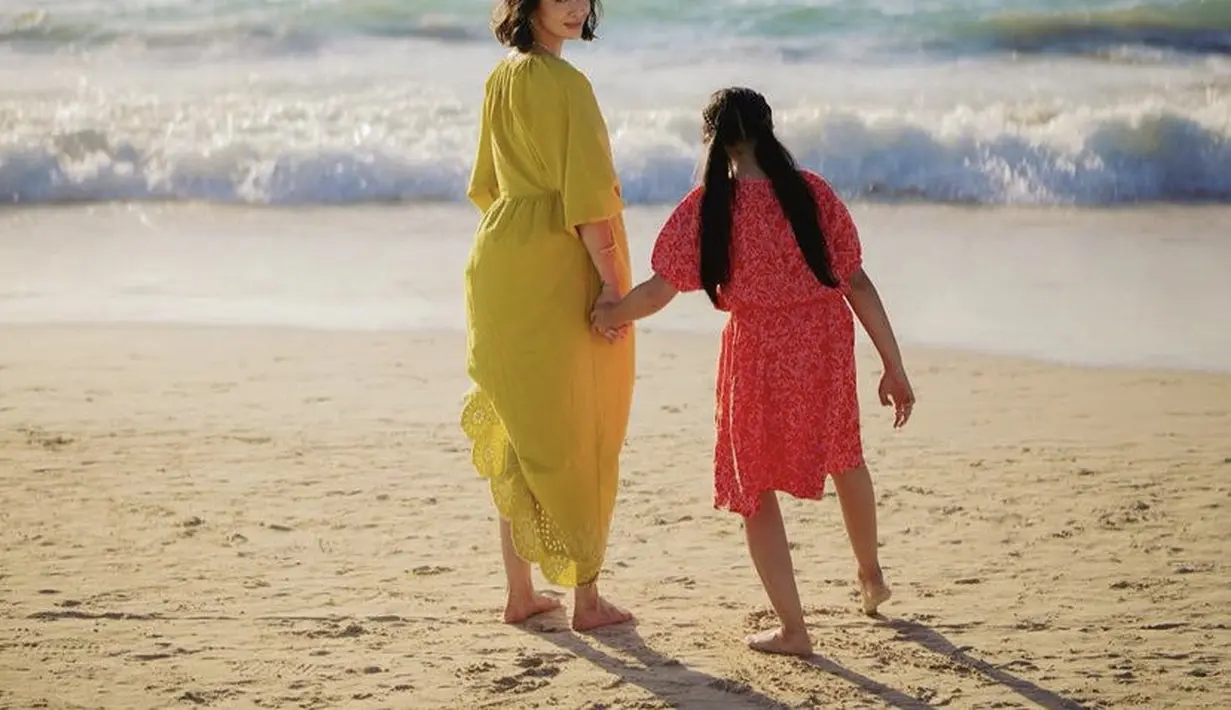 Marsha Timothy tampil dengan dress lengan 3/4 warna hijau bersama putrinya di pantai. @marshatimothy