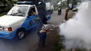 Petugas melakukan pengasapan (fogging) untuk memutus siklus hidup nyamuk aedes aegypti di Jalan Delima Raya, Jakarta Barat, Selasa (30/4/2019). Pengasapan itu untuk mencegah penyebaran wabah penyakit Demam Berdarah Dengue (DBD) saat musim hujan mulai terjadi di Jakarta. (Liputan6.com/Johan Tallo)