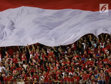 Bendera Merah Putih raksasa dibawa pendukung timnas U-22 Indonesia saat laga penyisihan Grup B melawan Timnas Vietnam U-22 di Stadion Selayang, Selangor, Selasa (22/8). Indonesia bermain imbang melawan Vietnam dengan skor 0-0. (Liputan6.com/Faizal Fanani)