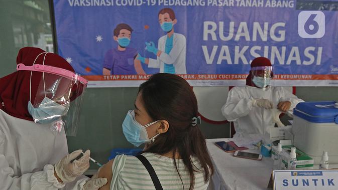 Seorang wanita menjalani vaksinasi COVID-19 di Pasar Tanah Abang Blok A, Jakarta, Rabu (17/2/2021). Vaksinasi COVID-19 tahap kedua yang diberikan untuk pekerja publik dan lansia itu dimulai dari pedagang Pasar Tanah Abang di blok A, B, F, dan G. (Liputan6.com/Herman Zakharia)