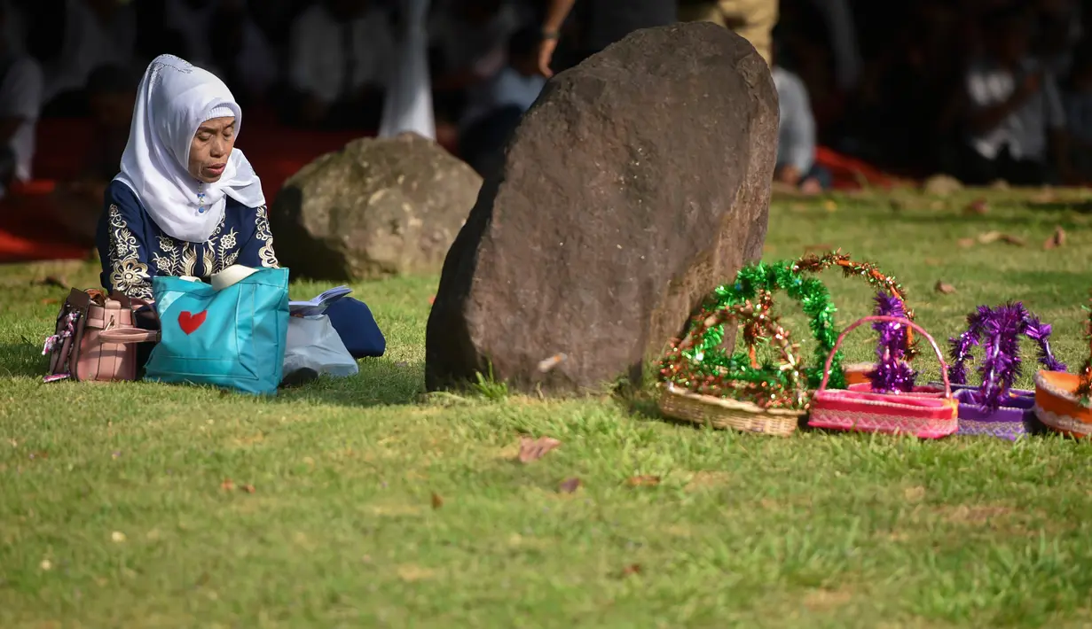 Seorang wanita berdoa saat ziarah di Kuburan Massal Ulee Lheue selama peringatan 14 tahun tsunami Aceh di Banda Aceh, Rabu (26/12). Sejumlah warga mengenang keluarga yang meninggal akibat bencana tsunami di Aceh 14 tahun silam. (Chaideer MAHYUDDIN / AFP)