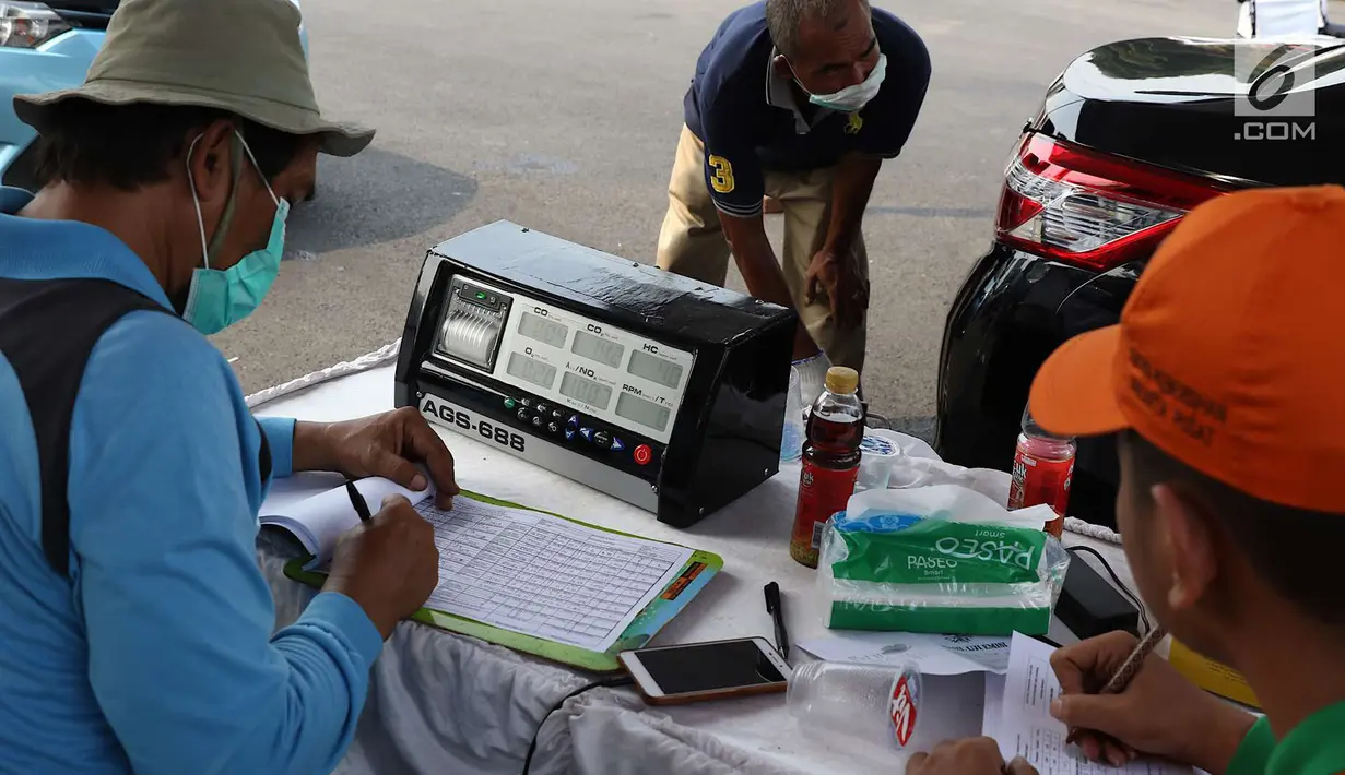 Petugas sudin lingkungan hidup melakukan uji emisi gas buang kendaraan di kawasan Senayan, Jakarta, Rabu (18/7). Uji emisi gratis dilakukan untuk menekan tingkat pencemaran udara akibat gas buang kendaraan. (Liputan6.com/Immanuel Antonius)