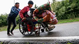 Migran Venezuela, Jefferson Alexis mendorong kursi roda ayahnya, Jose Agustin Lopez di Norte de Santander Department, Kolombia, 15 September 2018. Sang ayah mengalami cacat dan terkena luka infeksi daerah anus dan rektum. (AFP/SCHNEYDER MENDOZA)