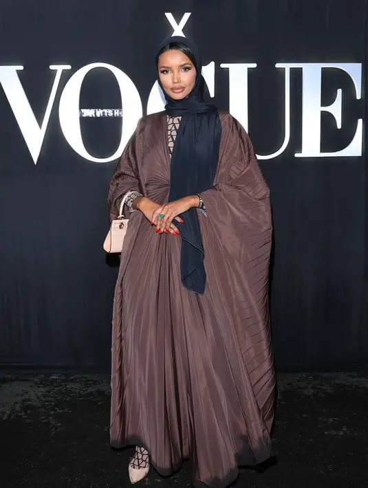 Melihat gaya Halima Aden, model berhijab asal Somalia-Amerika ini memang selalu menyenangkan. Menghadiri salah satu acara Vogue, Halima tampil cantik bak boneka dengan dress bersiluet abaya pleats berwarna cokelat, dipadunya dengan hijab hitam. [Foto: Instagram/halima]