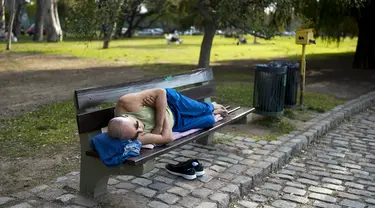 Seorang pria beristirahat di bangku taman di Buenos Aires, Argentina, Rabu, 2 Agustus 2023. Ibu kota Argentina memecahkan rekor awal Agustus terpanas dalam 117 tahun terakhir. (AP Photo/Natacha Pisarenko)