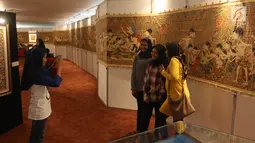 Pengunjung berfoto dengan latar belakang karya-karya Panji dalam Festival Panji Internasional di Perpustakaan Nasional, Jakarta, Selasa (10/7). Pameran Panji tersebut berlangsung hingga 11 Juli 2018. (Liputan6.com/Arya Manggala)