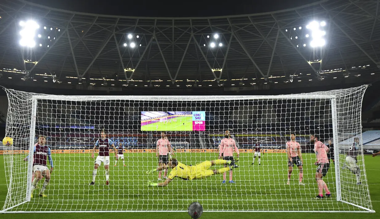 Pemain West Ham United Issa Diop (kanan) mencetak gol ke gawang Sheffield United pada pertandingan Liga Inggris di London Stadium, London, Inggris, Senin (15/2/2021). West Ham United menang 3-0. (Glyn Kirk/Pool via AP)