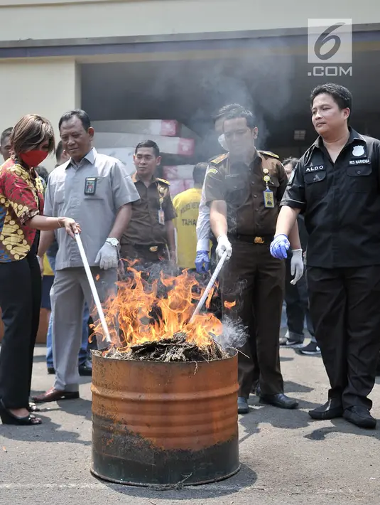 Petugas Satresnarkoba melakukan pemusnahan barang bukti ganja dengan cara dibakar di Halaman Polres Jakarta Utara, Rabu (28/3). Petugas memusnahkan 39,341 kilogram ganja dan sabu seberat 382,97 gram. (Merdeka.com/Iqbal S. Nugroho)