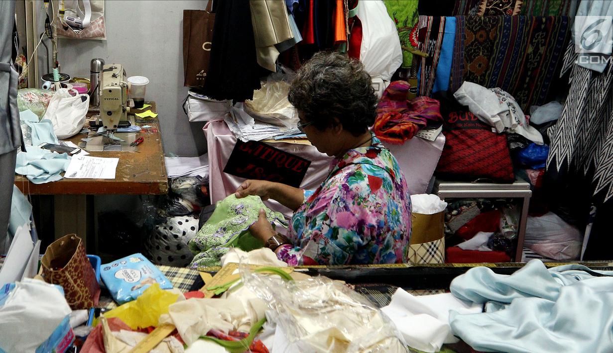 Seorang ibu menjahit pakaian di Pasar Mayestik, Jakarta Selatan, Senin (11/6). Para penjahit mengaku kebanjiran order sejak pertengahan Ramadan hingga jelang Lebaran. (Liputan6.com/JohanTallo)