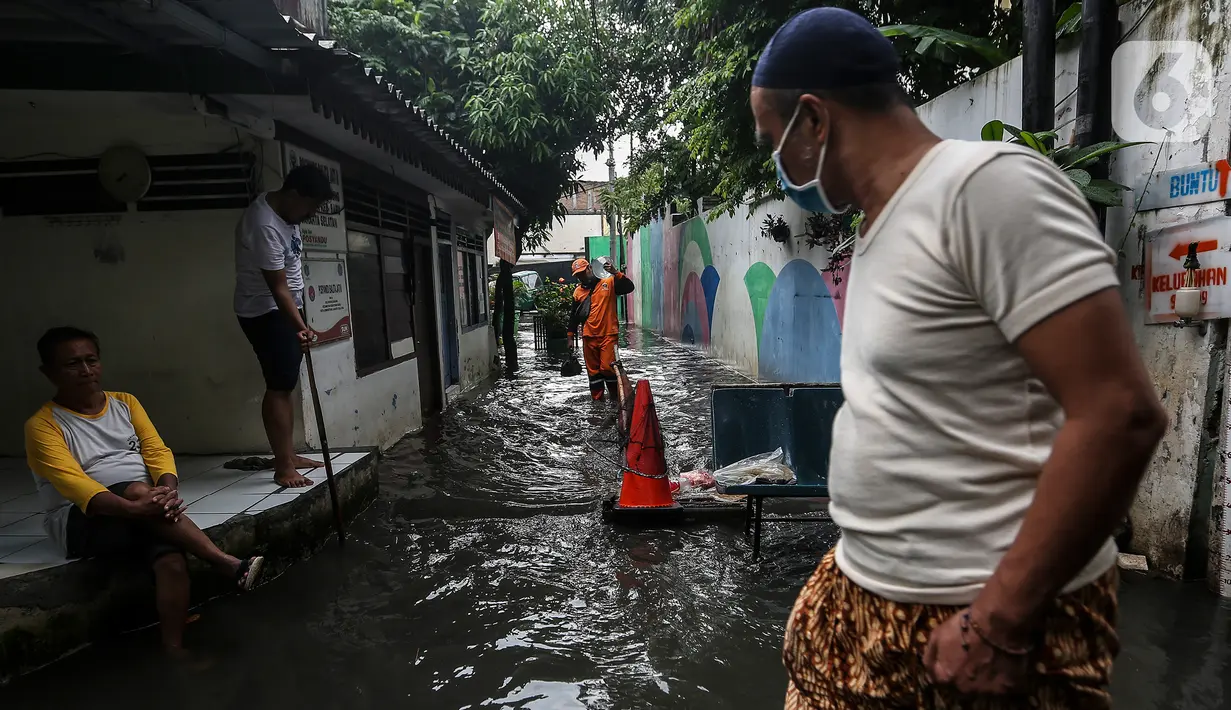 Warga beraktivitas saat banjir merendam lingkungan rumah tempat tinggal mereka di kawasan kecamatan Kebayoran Baru, Jakarta, Senin (25/01/2021). Hujan deras yang mengguyur Jakarta hari ini, Senin (25/1) menyebabkan terjadinya banjir di kawasan permukiman tersebut. (Liputan6.com/Johan Tallo)