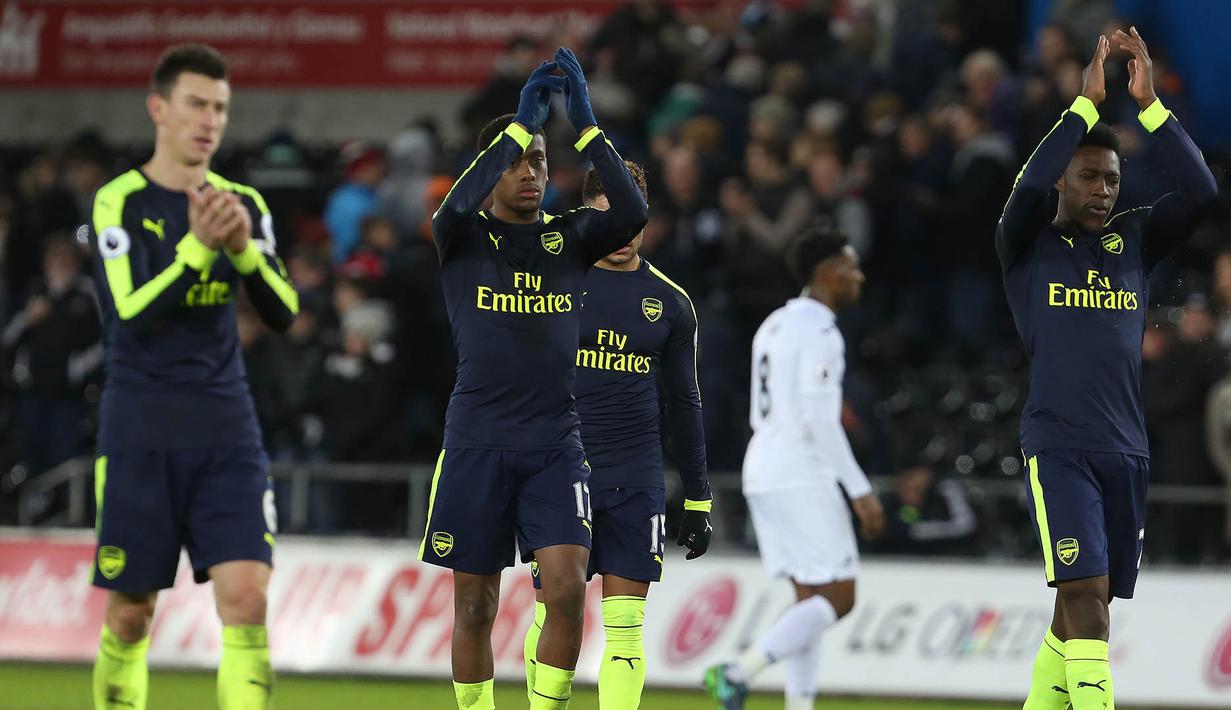 Kapten Arsenal, Laurent Koscielny, bersama rekan-reaknnya menyapa suporter usai laga melawan Swansea. Berkat kemenangan ini Arsenal naik ke peringkat tiga klasemen Liga Inggris. (AFP/Geoff Caddick)