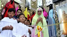 Oki Setiana Dewi dan suami bersama anak panti asuhan berdoa bersama sebelum meresmikan gerai busana muslimnya yang diberi brand OSD di Thamrin City, Jakarta, Selasa (13/1/2015). (Liputan6.com/Faisal R Syam)