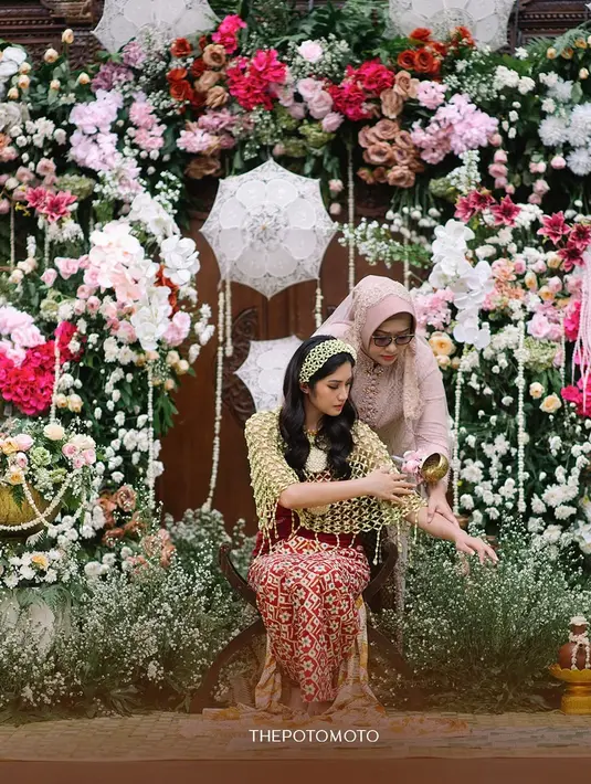 Saat upacara siraman berlangsung, kebaya tersebut dilepas dan digantikan dengan cape berbahan roncean melati yang memperkuat nuansa sakral. Ia juga mengenakan bandana melati di kepalanya. [@thepotomoto].