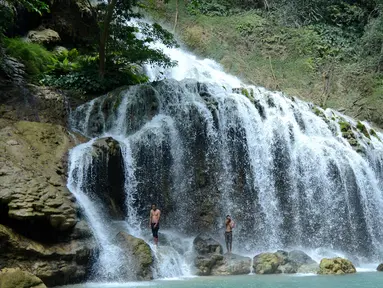 Wisatawan menikmati Air Terjun Lapopu yang terletak di Desa Hatikuloku, Kecamatan Wanokaka, Kabupaten Sumba Barat, NTT (21/10). Air Terjun Lapopu menjadi daya tarik wisatawan domestik maupun asing dengan pesona keindahannya. (AFP Photo/Sony Tumbelaka)