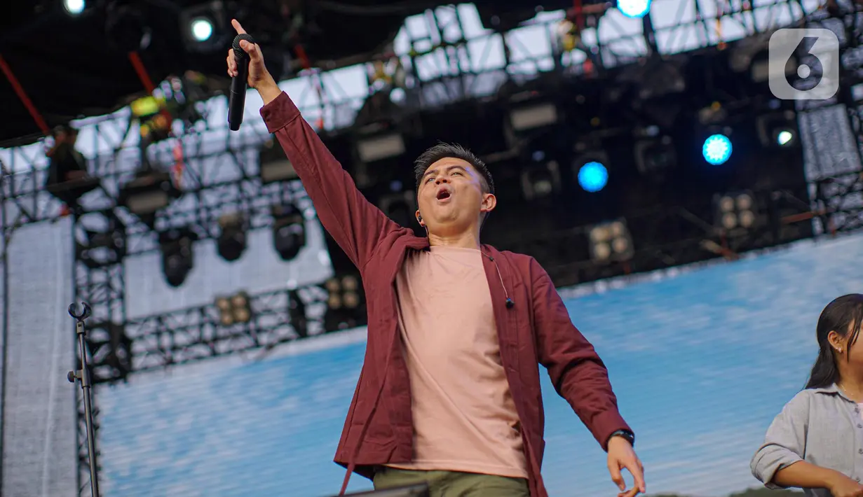 Vokalis band Base Jam, Sigit mengajak penonton bernyanyi saat tampil dalam festival musik Manggungdi BSD Tangerang, Sabtu (3/9/2022). Dalam penampilannya Base Jam tampil enerjik dengan membawakan lagu hitsnya diantaranya bukan punjaga, dan rindu. (Liputan6.com/Faizal Fanani)