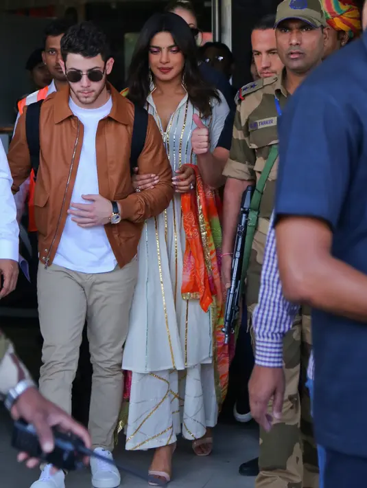 Aktris India Priyanka Chopra (tengah) dan musisi AS Nick Jonas (kiri) tiba di Jodhpur, Rajasthan, India, Kamis (29/11). Berdasarkan laporan India Today, Chopra dan Nick bakal menggelar ritual berjoget ala Bollywood. (AP Photo/Sunil Verma)