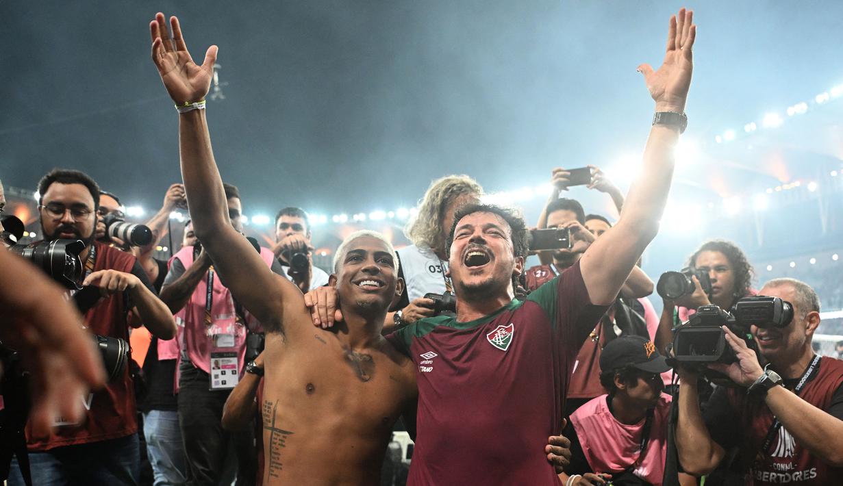 Pemain Fluminense, John Kennedy (kiri) dan pelatih Fernando Diniz merayakan kemenangan atas Boca Juniors pada final Copa Libertadores yang berlangsung di Maracana Stadium , Rio de Janeiro, Brasil, 5 November 2023 WIB. (AFP/Carl De Souza)