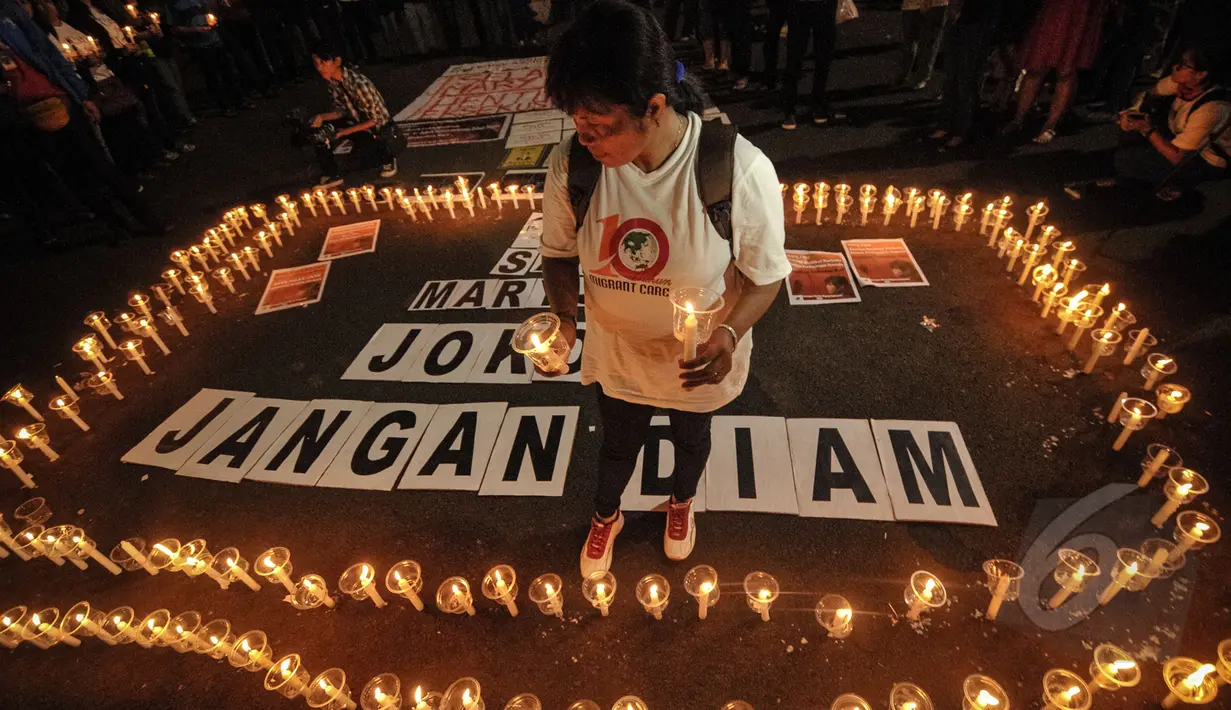 Seorang aktivis berdiri diantara ribuan lilin yang menyala dalam aksi damai di depan Istana Merdeka, Jakarta, Minggu (26/4/2015). Aksi tersebut meminta eksekusi atas Mary Jane dibatalkan. (Liputan6.com/Faial Fanani)