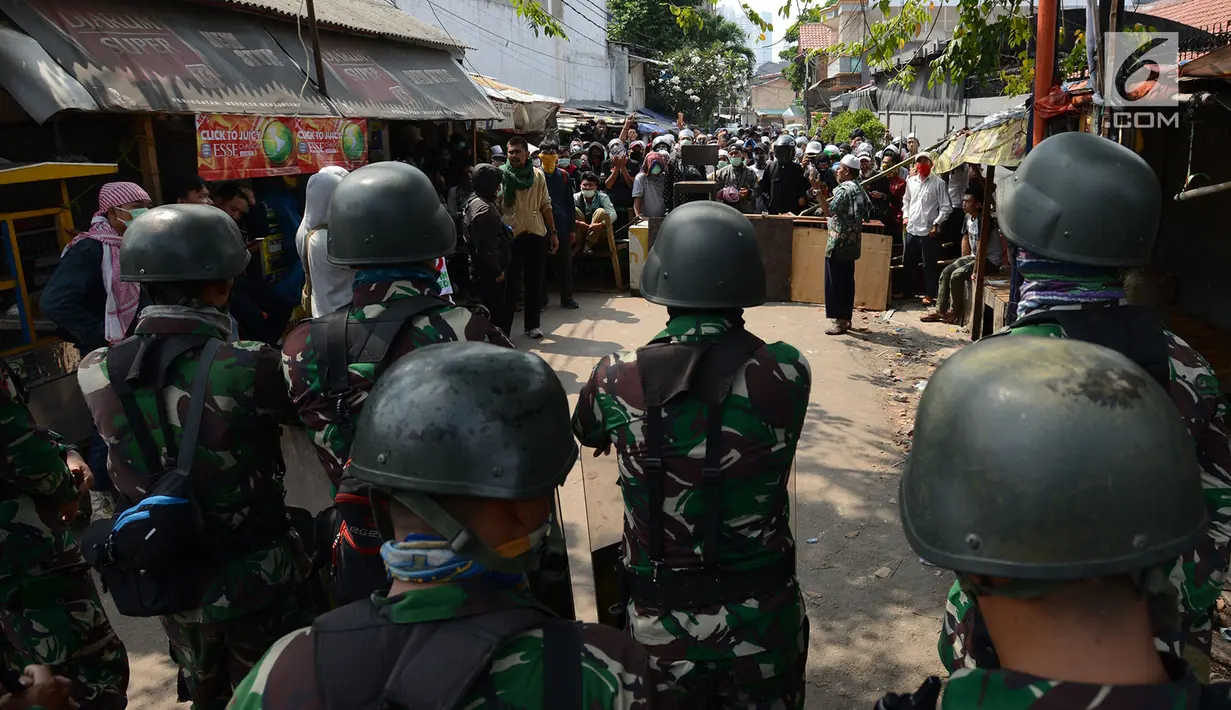 Personel TNI berdiskusi dan rekonsiliasi dengan warga untuk mencegah kerusuhan susulan di Jalan KS Tubun, Petamburan, Jakarta, Rabu (22/5/2019). Aparat keamanan berhasil menghalau massa aksi 22 Mei yang sebelumnya berkumpul di kawasan tersebut. (merdeka.com/Imam Buhori)