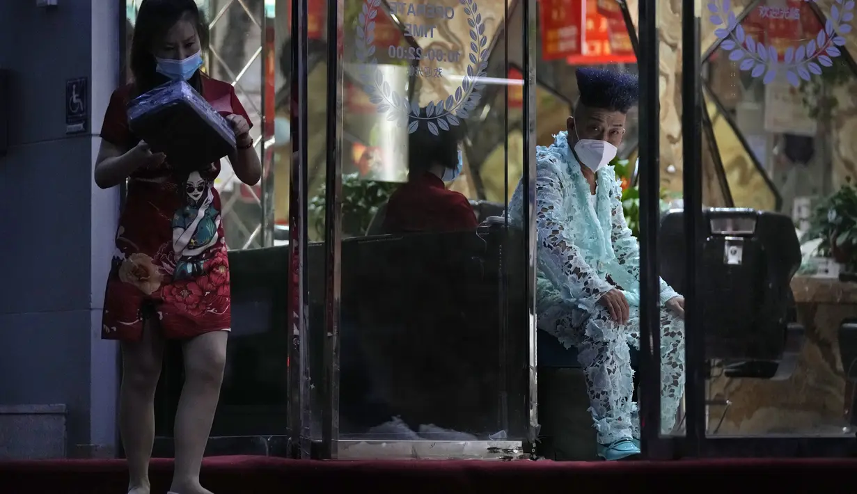 Pekerja di salon kecantikan menunggu pelanggan di Beijing (24/5/2022). Beijing memperpanjang perintah bagi pekerja dan pelajar untuk tinggal di rumah dan memerintahkan pengujian massal tambahan pada Senin ketika kasus COVID-19 meningkat di ibu kota China. (AP Photo/Ng Han Guan)