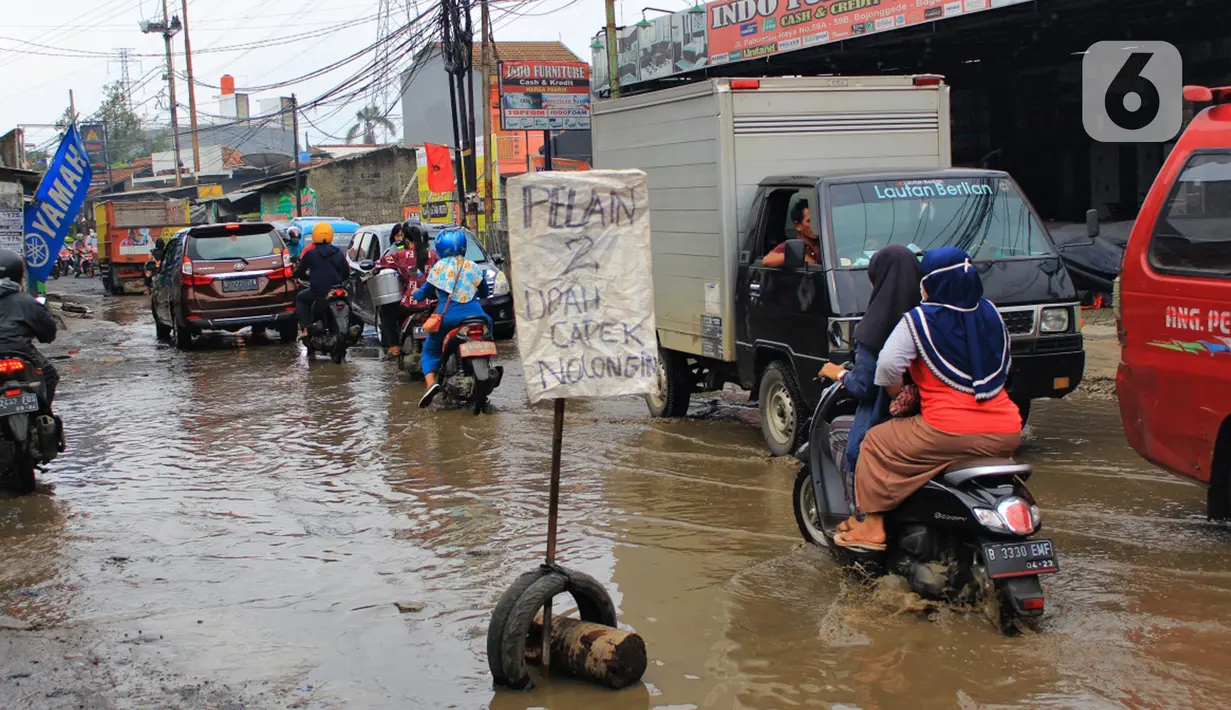 Kondisi jalan berlubang dan tergenang air di Jalan Raya Pabuaran, Citayam, Depok, Rabu (26/2/2020). Kerusakan disebabkan oleh kubangan air yang menggenangi jalan tersebut pada musim hujan  yang melanda Jabodetabek dua bulan terakhir. (merdeka.com/magang/Muhammad Fayyadh)