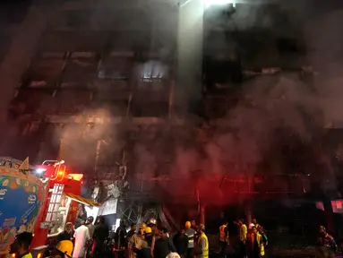 Petugas pemadam kebakaran berjuang untuk mengendalikan api di sebuah gedung komersial bertingkat di Karachi, Pakistan, Rabu (6/12/2023). Kebakaran besar menewaskan tiga orang dan merusak beberapa toko, kata polisi dan petugas penyelamat. (AP Photo/Fareed Khan)