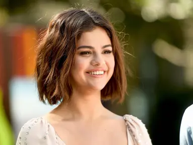 Aktris Selena Gomez tersenyum saat mempromosikan film terbarunya "Hotel Transylvania 3: Summer Vacation" di Sony Pictures Studios di Culver City, California (11/4). Selena Gomez tampil cantik dengan gaun berwarna krem. (Matt Winkelmeyer/Getty Images/AFP)