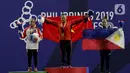 Lifter putri Indonesia, Lisa Setiawati (kiri) saat naik podium usai mendapatkan medali perak SEA Games 2019 cabang angkat besi nomor 45 kg di Stadion Rizal Memorial, Manila, Minggu (1/12/2019). Dirinya meraih perak dengan total angkatan 169 kg. (Bola.com/M Iqbal Ichsan)