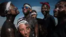 Orang-orang dengan tubuh dilumuri minyak hitam tertawa saat mengikuti festival tradisional Cascamorras di Baza, Spanyol, Rabu (6/9). Festival ini biasa dilakukan tanggal 6 September setiap tahunnya. (JORGE GUERRERO/AFP)