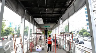 Pekerja menyelesaikan perbaikan halte transjakarta yang terbakar di Salemba, Jakarta, Selasa (7/7/2015). Halte tersebut rusak parah sebagai imbas dari terbakarnya bus Transjakarta koridor 5 pada hari Jumat (3/7) lalu. (Liputan6.com/Faizal Fanani)