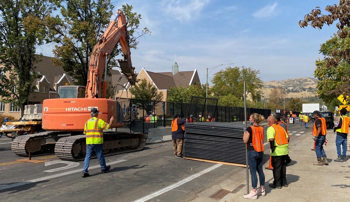 Pekerja mendirikan barikade beton dan pagar sementara di luar kompleks Universitas Utah di Salt Lake City, Senin (5/10/2020). Universitas Utah akan menjadi tuan rumah debat calon wakil presiden petahana Mike Pence dan Senator California Kamala Harris akan digelar pada Rabu 7 Oktober. (Daniel SLIM /