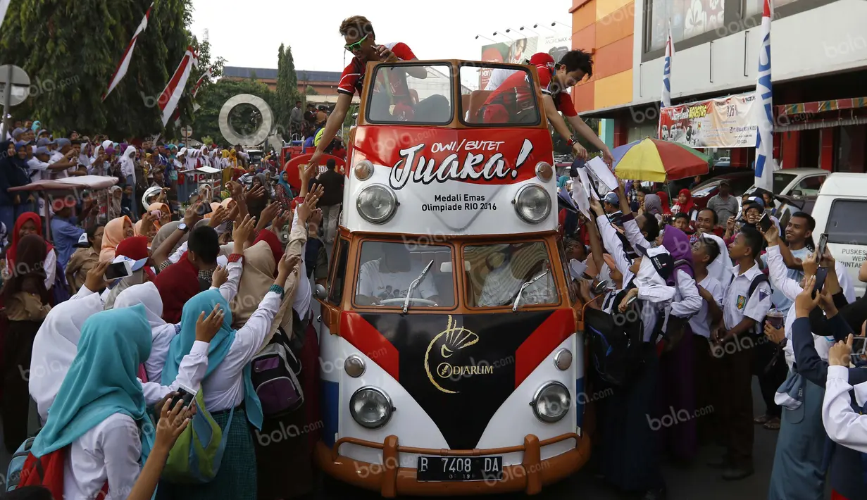 Peraih emas bulutangkis Olimpiade Rio 2016, Tontowi Ahmad dan Liliyana Natsir, disambut warga Kudus saat kirab melewati alun-alun kota Kudus, Kamis (1/9/2016). (Bola.com/Arief Bagus)